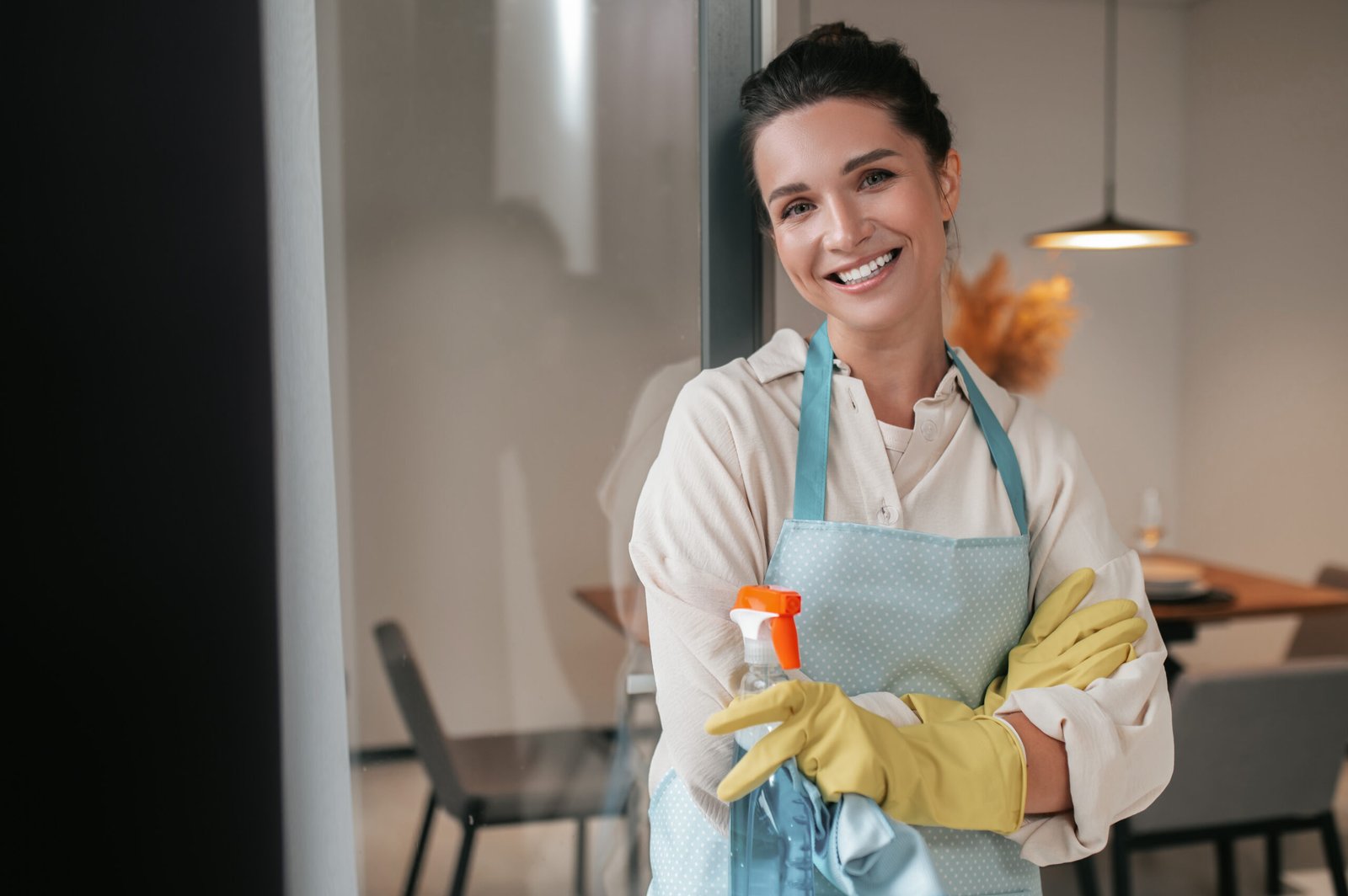 smiling housewife in apron standing in the kitchen